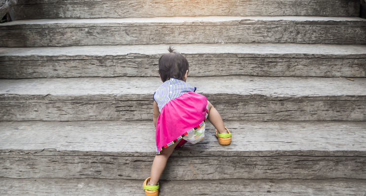 Infant crawling up concrete steps